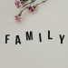 Elegant arrangement of pink flowers and family text on a white background, ideal for family themes.
