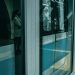 People waiting at Istanbul metro platform with reflections and modern architecture.
